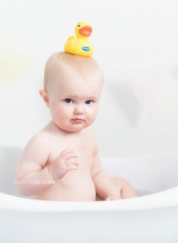 baby in the bath with duck on her head
