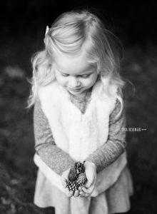 little girl with pinecones