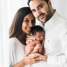 new parents looking at camera with baby