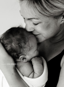 Newborn baby kissed by mum