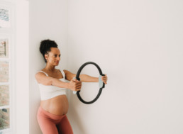 pregnant lady posing with pilates equiptment