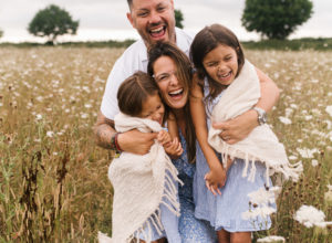 Family photo hugging in field